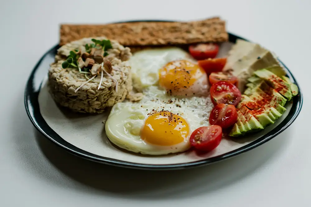 petit-déjeuner sain salé avec des oeufs, de l'avocat, avoine et tomates