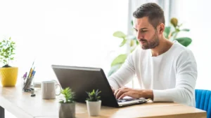 homme sur un ordinateur portable recherchant des plateformes freelances