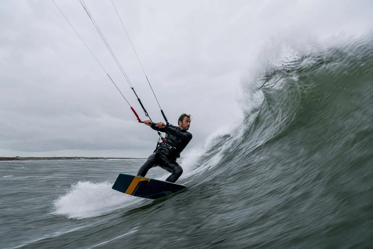 Kitesurfeur surfant une vague à La Torche en Bretagne par vent d'ouest